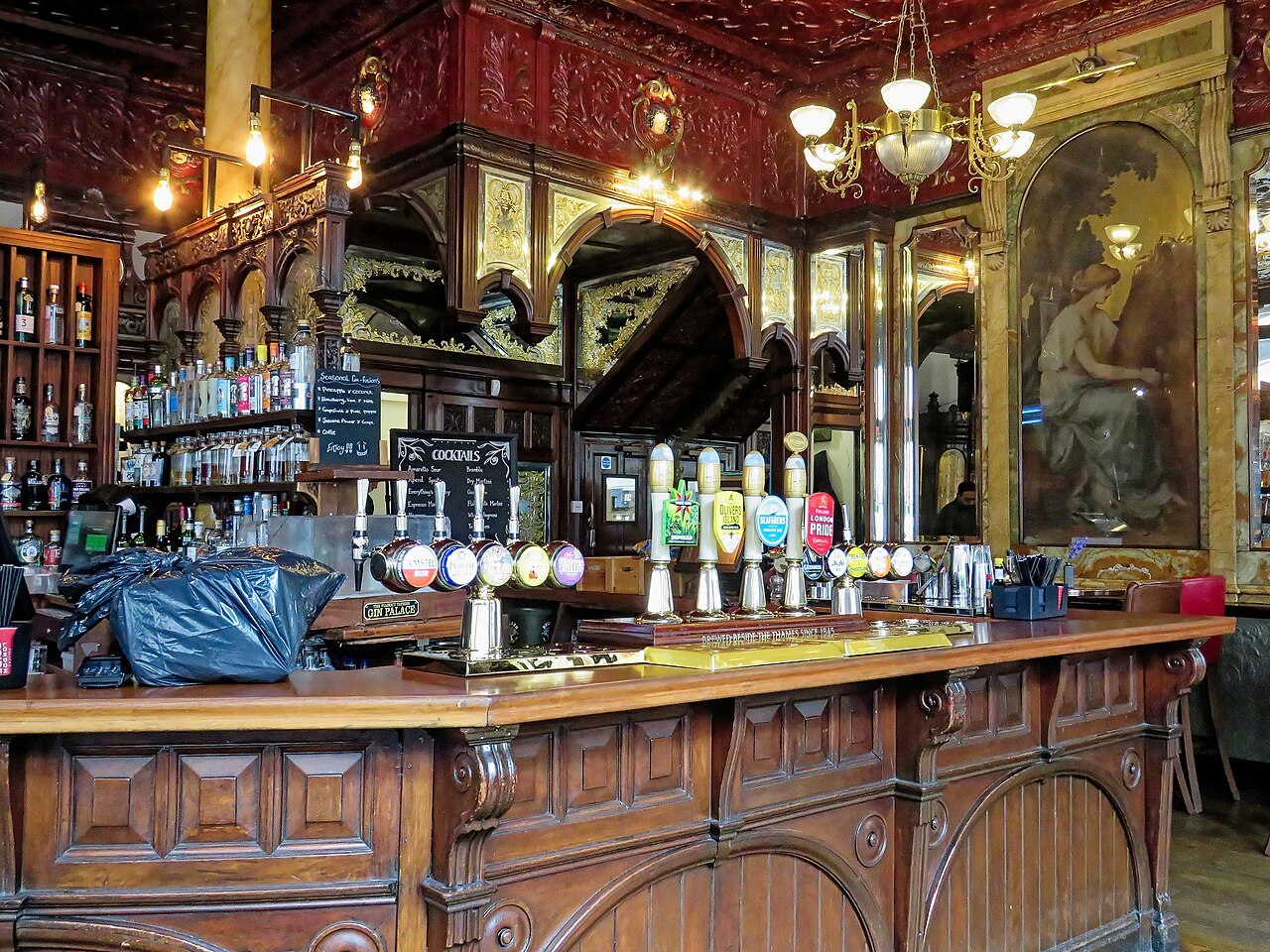 The interior of a traditional pub, with a long wooden bar counter