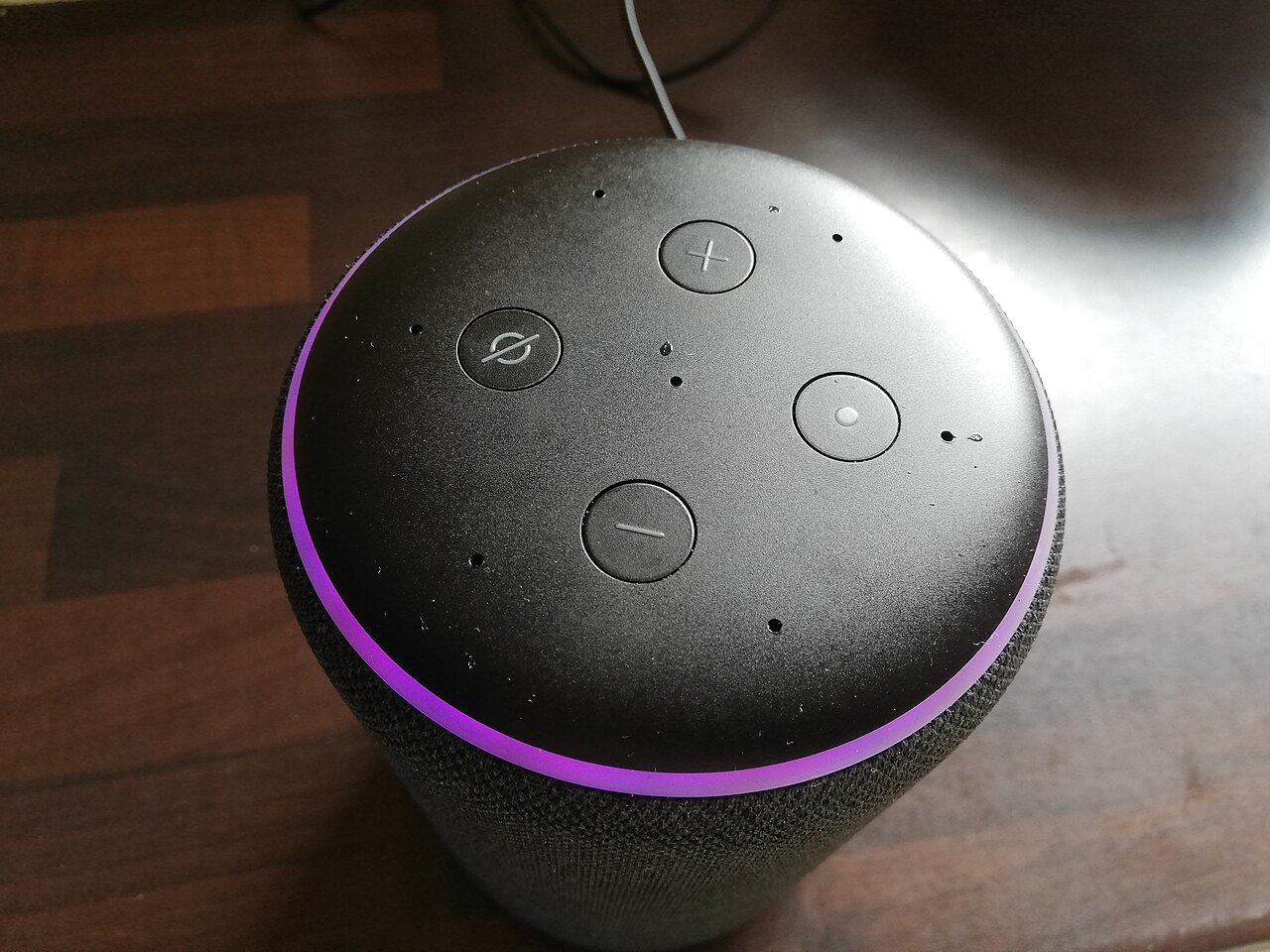 An Amazon Echo smart speaker with its light ring glowing purple