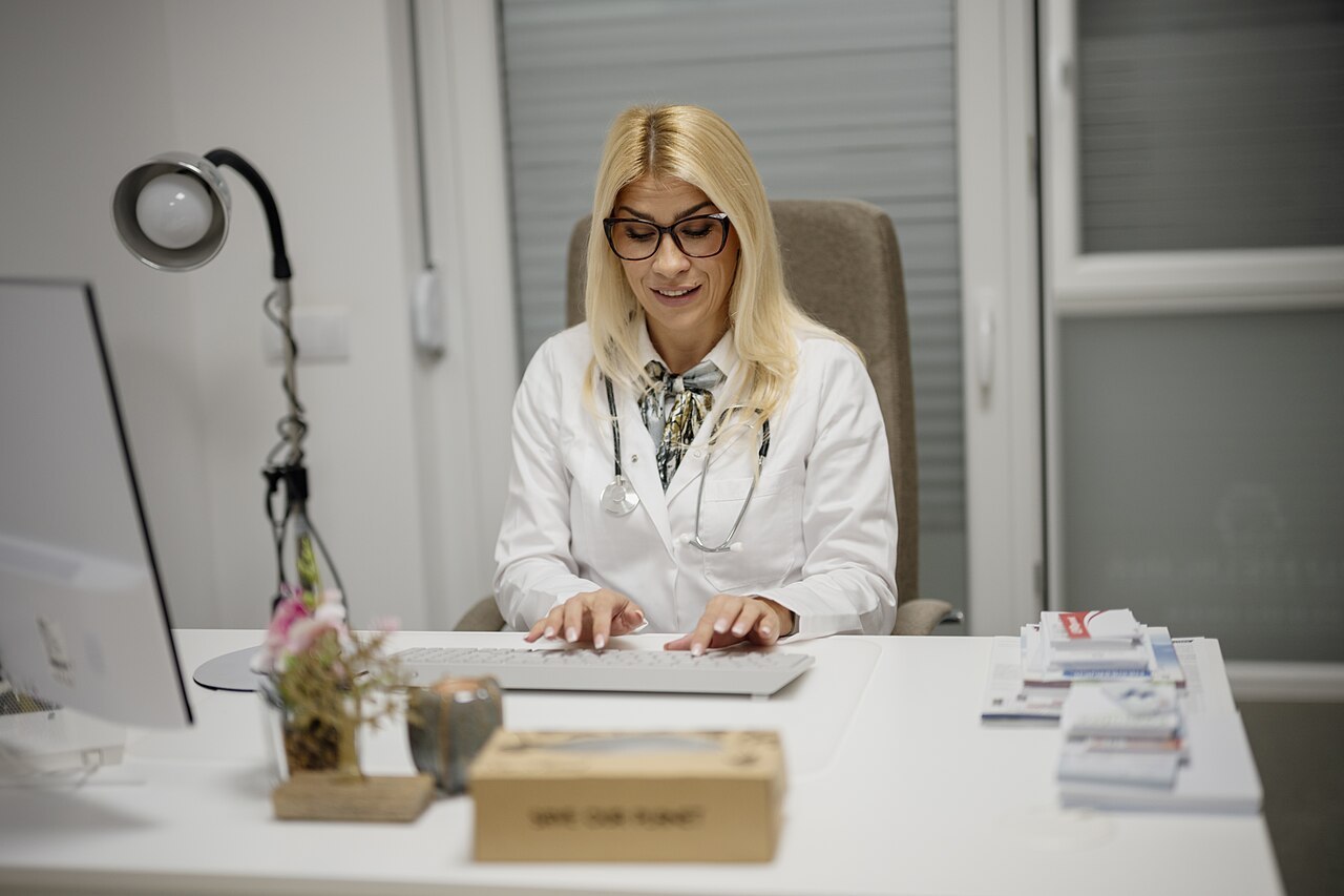 A doctor reviewing information on a computer during a consultation
